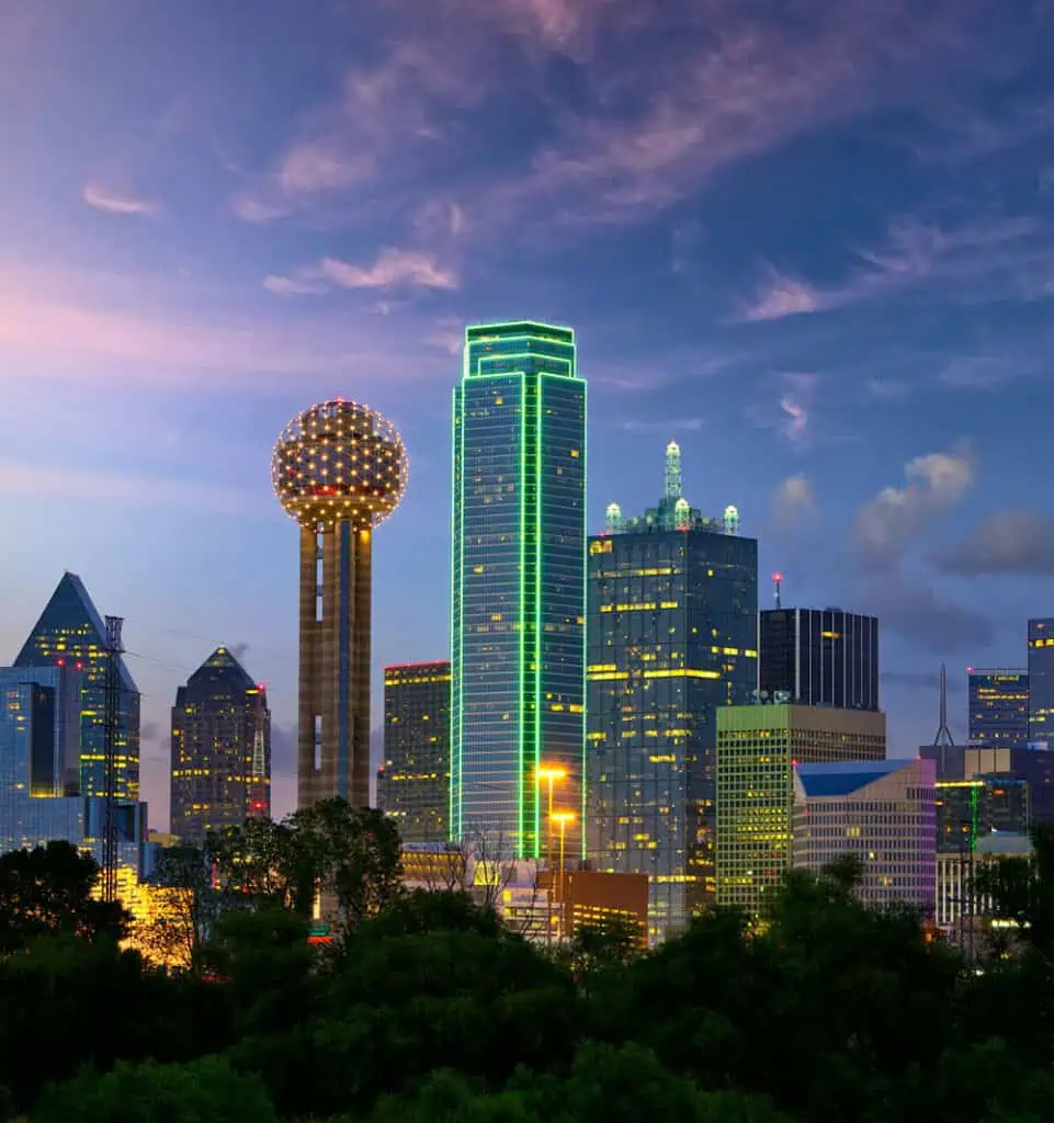 Modern Dallas skyline with illuminated skyscrapers at dusk, showcasing urban development and cityscape beauty.
